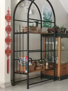 コタバルにあるLittle Cozy Homestayのガラス戸とテーブル付きのアーチ型の鉄棚