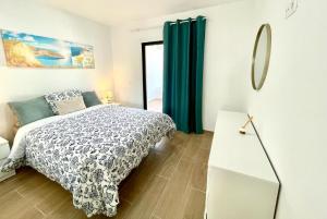 sypialnia z łóżkiem, stołem i lustrem w obiekcie Seafront Apartment in Amarilla Golf w San Miguel de Abona