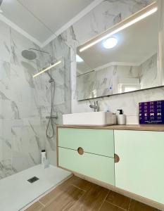 biała łazienka z umywalką i prysznicem w obiekcie Seafront Apartment in Amarilla Golf w San Miguel de Abona