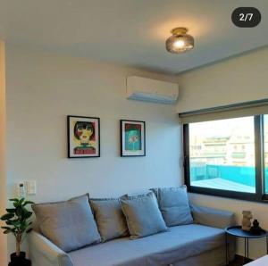 - un canapé bleu dans le salon doté d'une fenêtre dans l'établissement BlueMotion - 4PortCenterΑpartment, au Pirée