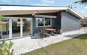 a small house with a table and chairs on a patio at Two-Bedroom Holiday Home Broager With A Fireplace 07 in Broager