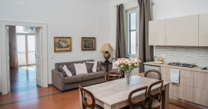 una cucina e un soggiorno con tavolo e divano di Beatrice Luxury Apartment a Vietri