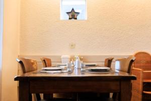 a wooden table with chairs and a star on the wall at Hotel Berg en Bos in Apeldoorn