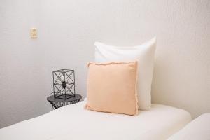 - un oreiller assis au-dessus du lit et une table de chevet dans l'établissement Hotel Berg en Bos, à Apeldoorn