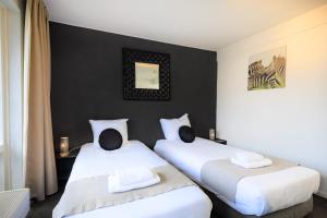 two beds in a room with black walls at Hotel Berg en Bos in Apeldoorn