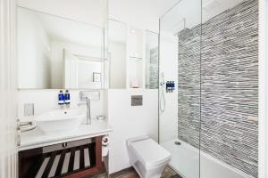 y baño con aseo, lavabo y ducha. en Hotel Indigo - Edinburgh - Princes Street, an IHG Hotel en Edimburgo