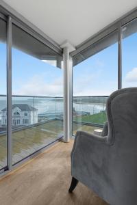 a living room with a couch and large windows at 55 North Apartments Portrush in Portrush