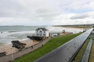 a building on the beach next to the ocean at 55 North Apartments Portrush in Portrush