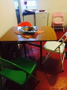 a wooden table with chairs and a magazine on it at Carpe Diem Rooms Flat near Zone 1 in London