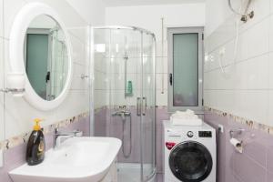 a bathroom with a sink and a washing machine at Beach Heaven Apartments in Durrës