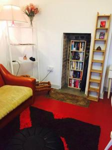 a living room with a couch and a book shelf at Carpe Diem Rooms Flat near Zone 1 in London