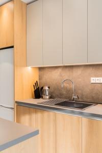 a kitchen with white cabinets and a sink at #Nereids Apts by halu! Apartments in Thessaloniki