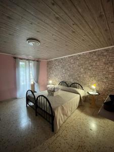 um quarto com 2 camas e uma parede de tijolos em Dimora Selù em Laurino