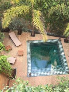 - une vue sur la piscine dans le jardin dans l'établissement Riad Dar Pierre, à Fès