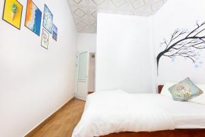 a white bedroom with a bed and a window at Cat Ba Countryside Homestay in Cat Ba