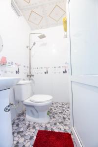a white bathroom with a toilet and a shower at Cat Ba Countryside Homestay in Cat Ba