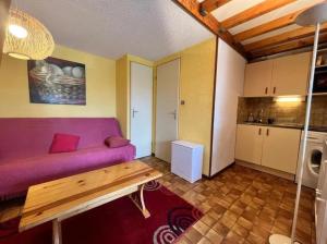 un salon avec un canapé violet et une table dans l'établissement Bret, à Valras-Plage