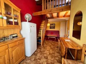 une cuisine avec un réfrigérateur et un mur rouge dans l'établissement Bret, à Valras-Plage