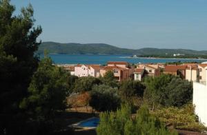 un grupo de casas y una gran masa de agua en Apartments Kodzoman, en Brodarica