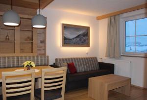 een woonkamer met een tafel en een bank bij Gästehaus Auer in Holzgau