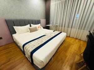 1 dormitorio con 1 cama grande con sábanas blancas en Vortex Suites Klcc by Rit Villa en Kuala Lumpur