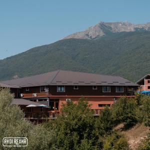 a large building with a mountain in the background at Hotel Avdi Rexha in Kolgecaj