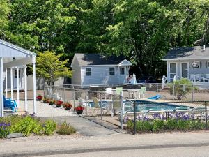 a yard with a pool and chairs and a house at Marvin Gardens Motel Old Orchard Beach in Old Orchard Beach