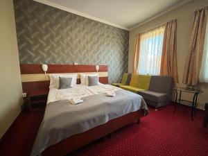 een hotelkamer met een bed en een stoel bij Libra Hotel in Veresegyház