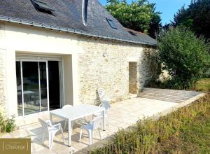 une terrasse avec une table et des chaises devant un bâtiment dans l'établissement L'éco-Domaine du Chalonge, à Héric