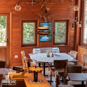 un comedor con mesas, sillas y ventanas en Hotel Avdi Rexha, en Kolgecaj