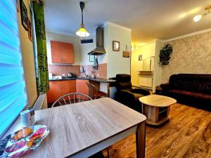 a living room with a table and a kitchen at Apartment Hotel Rubini in Ventspils