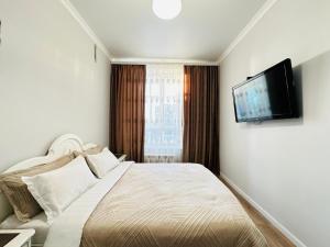 1 dormitorio con 1 cama y TV de pantalla plana en Grand champion en Astaná