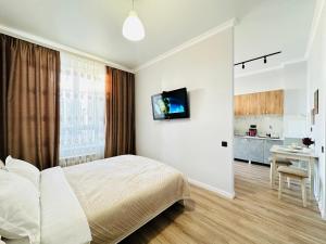 1 dormitorio con 1 cama y TV en la pared en Grand champion en Astaná