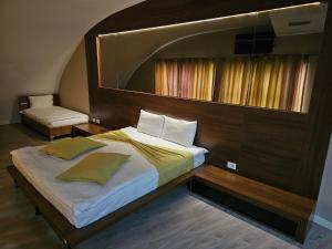 una camera con un grande letto con testiera in legno di HOTEL BENITA a Pejë