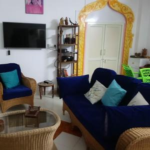 a living room with a blue couch and chairs at Casa di Mara in Puttaparthi