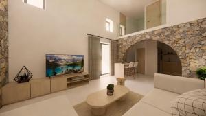 un salon avec un canapé et une télévision sur un mur dans l'établissement Kallithea Luxury Villas #4, à Koskinou