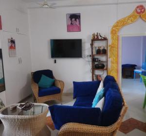 a living room with a blue couch and chairs at Casa di Mara in Puttaparthi