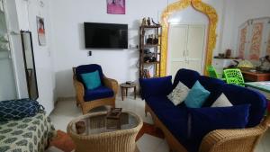 a living room with a blue couch and chairs at Casa di Mara in Puttaparthi +12 photos