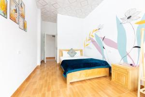 a bedroom with a bed with a blue blanket at Cat Ba Countryside Homestay in Cat Ba