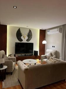 sala de estar con sofá y TV en شقة حي الخالدية مع دخول ذاتي, en Al Jubail