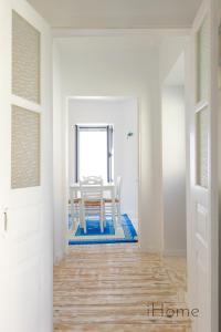 a dining room with a white table and a white door at Kokkari's Destiny - at the heart of the City Center in Kokkari