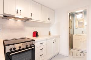 uma cozinha com armários brancos e um forno com placa de fogão em Kokkari's Destiny - at the heart of the City Center em Kokkari