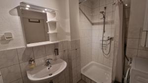 y baño blanco con lavabo y ducha. en Apartment Wetter, en Wetter