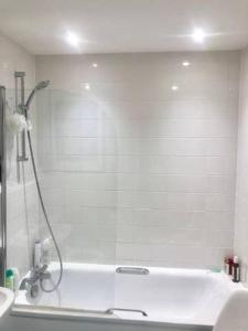 uma casa de banho com um chuveiro e uma banheira em Central Room In Shoreditch em Londres