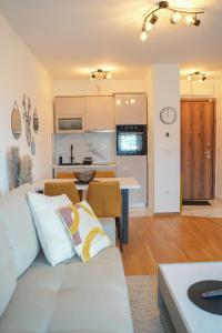 un salon avec un canapé blanc et une cuisine dans l'établissement Apartment Forma, à Zlatibor