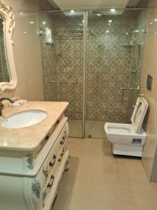 een badkamer met een toilet, een wastafel en een douche bij JC Dale in Kollam