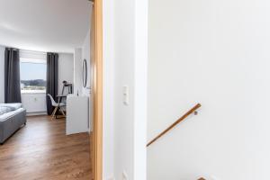 ein Schlafzimmer und ein Wohnzimmer mit weißen Wänden in der Unterkunft Schicke zentrale Maisonette-Wohnung mit City-View in Saarbrücken
