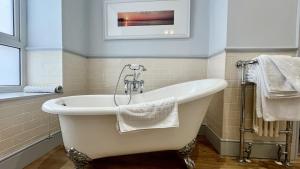 a bath tub in a bathroom with a picture on the wall at Trearddur Bay Hotel in Trearddur