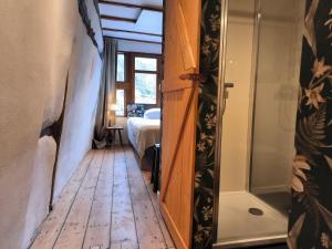 un pasillo con una puerta que conduce a un dormitorio con bañera en petite maison am Mühlenberg en Monschau