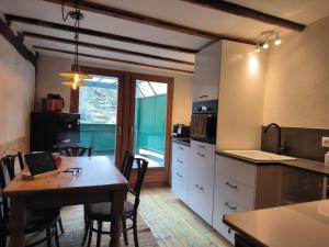 une cuisine avec une table et des chaises ainsi qu'une fenêtre dans l'établissement petite maison am Mühlenberg, à Monschau